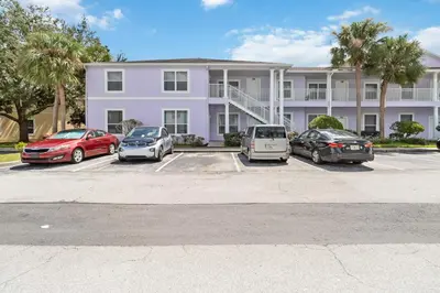 a group of cars parked in a parking lot in front of a building at Huge Screened Patio That Overlooks Lake Buck, Near Famous Attractions!! in Orlando