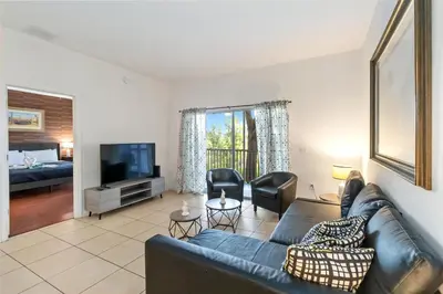 a living room with a couch and a tv at Huge Screened Patio That Overlooks Lake Buck, Near Famous Attractions!! in Orlando