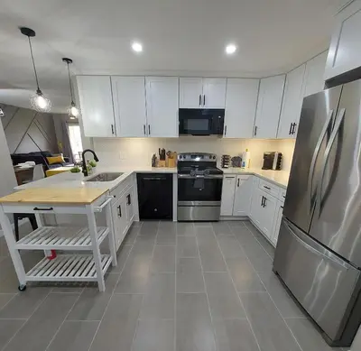 a kitchen with white cabinets and a stainless steel refrigerator at Amazing 32 Condo, Gated Community At Club Cortile!! in Kissimmee