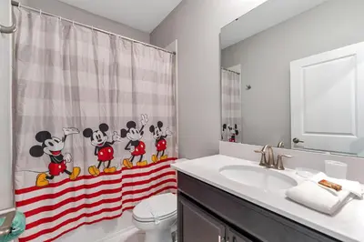 a bathroom with a sink and a toilet and a shower curtain at Storey Lake Resort, Private Pool, And Much More!! in Kissimmee