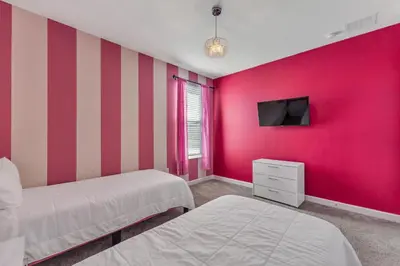 a bedroom with two beds and a red wall at Storey Lake Resort, Private Pool, And Much More!! in Kissimmee