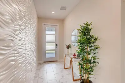 a hallway with a white wall with a plant at 2751 BD -Luxury 5BR Single Family - Private Pool in Kissimmee