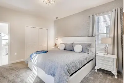 a white bedroom with a bed and a window at 2773 BD - 5Bd Home with Private Pool 14 Guests in Kissimmee