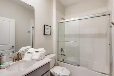 a white bathroom with a sink and a shower at 2773 BD - 5Bd Home with Private Pool 14 Guests in Kissimmee