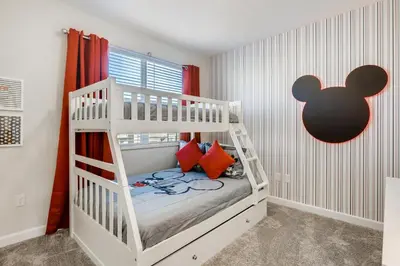 a bedroom with a white bunk bed with red pillows at 2773 BD - 5Bd Home with Private Pool 14 Guests in Kissimmee