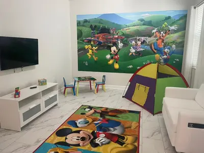 a living room with a disney mural on the wall at 2859 BD - Grand Luxury Villa with a Sparkling Pool in Kissimmee