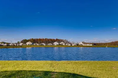 a large blue lake with houses in the background at 2859 BD - Grand Luxury Villa with a Sparkling Pool in Kissimmee