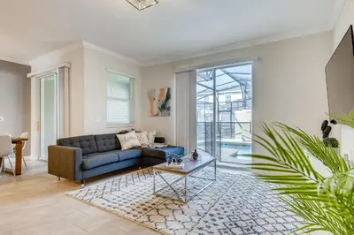 a living room with a blue couch and a table at 4321 QS - Magical Haven Townhome w Pool in Kissimmee