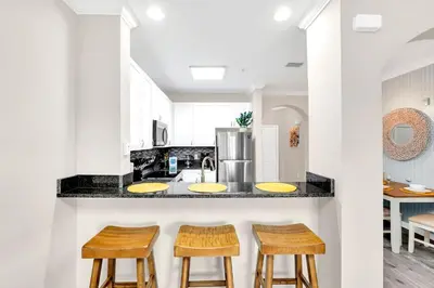 a kitchen with two sinks and two stools at 2BR Condo with Pool - Near Disney in Orlando