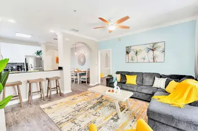 a living room with a couch and a table at 2BR Condo with Pool - Near Disney in Orlando