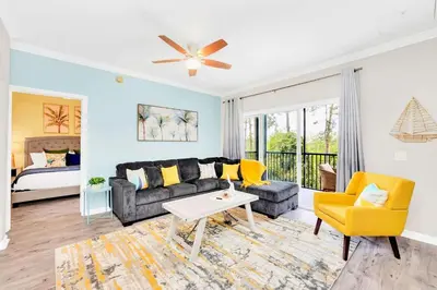 a living room with a couch and a table at 2BR Condo with Pool - Near Disney in Orlando