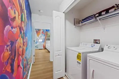 a kitchen with a washing machine and a painting on the wall at Peach Odyssey At Storey Lake By Shine Villas #908 in Kissimmee