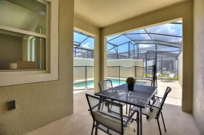 a dining room with a table and chairs on a balcony at Magic Lily - Storey Lake By Shine Villas #834 in Kissimmee