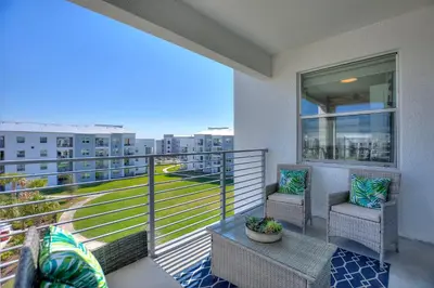a balcony with two chairs and a view of a building at Blue Toucan At Storey Lake By Shine Villas #402 in Kissimmee