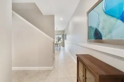 a hallway with a staircase with a painting on the wall at Star Hideaway At Storey Lake By Shine Villas #716 in Kissimmee
