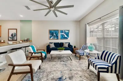 a living room with a blue couch and chairs at Star Hideaway At Storey Lake By Shine Villas #716 in Kissimmee