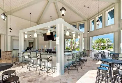 a covered patio with tables and chairs and a bar at Happy Haven At Storey Lake Resort By Shine Villas #409 in Kissimmee