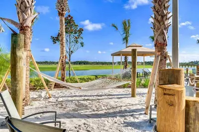 a hammock on a beach with palm trees at Happy Haven At Storey Lake Resort By Shine Villas #409 in Kissimmee