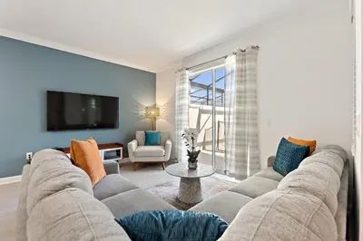 a living room with a couch and a tv at Blue Beach At Storey Lake By Shine Villas #400 in Kissimmee