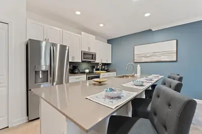 a kitchen with a table and a refrigerator at Blue Beach At Storey Lake By Shine Villas #400 in Kissimmee