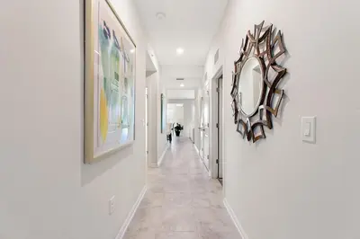 a hallway with paintings and a mirror on the wall at Tranquility At Storey Lake By Shine Villas #828 in Kissimmee