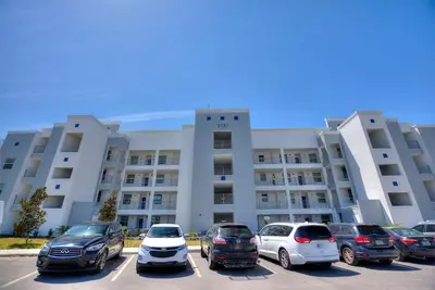 a parking lot with cars parked in front of a building at Tranquility At Storey Lake By Shine Villas #828 in Kissimmee