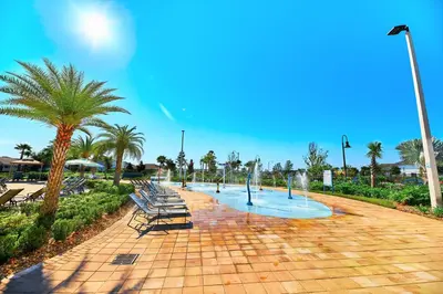 a park with benches and a fountain and palm trees at Vacation Meadows - Storey Lake By Shine Villas #710 in Kissimmee