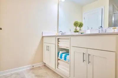 a white bathroom with a sink and a mirror at Vacation Meadows - Storey Lake By Shine Villas #710 in Kissimmee