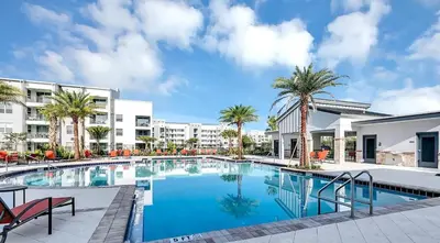 a swimming pool with palm trees and buildings at Vacation Meadows - Storey Lake By Shine Villas #710 in Kissimmee