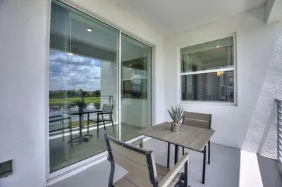 a dining room with a table and chairs and a window at Decadent Penguin - Storey Lake By Shine Villas #704 in Kissimmee