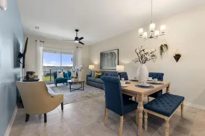 a dining room and living room with a table and chairs at Lake View At Storey Lake By Shine Villas #703 in Kissimmee