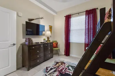 a bedroom with a bed and a dresser and a tv at Lake View At Storey Lake By Shine Villas #703 in Kissimmee