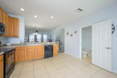a kitchen with wooden cabinets and a sink and a toilet at Beautiful Townhome, Vista Cay Resort Direct - 4010 in Orlando