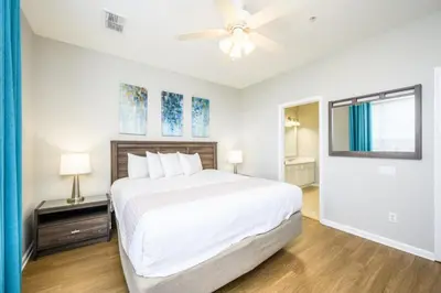 a white bedroom with a bed and a ceiling fan at Beautiful Townhome, Vista Cay, Near Parks! 4018 in Orlando