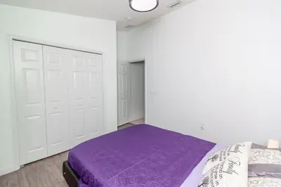 a bedroom with a purple bed and white walls at Gorgeous Fully Furnished 2-Bedroom Luxury Villa in Kissimmee