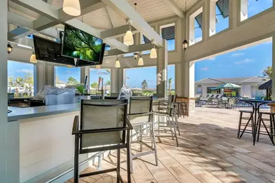 a patio with chairs and a bar with a flat screen tv at Serenity Haven, Bliss, Storey Lake By Shine Villas #701 in Kissimmee
