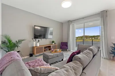 a living room with a couch and a flat screen tv at Sweet Suite Sleeps 6 Storey Lake By Shine Villas #903 in Kissimmee