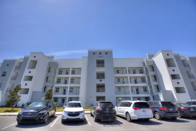 a parking lot with cars parked in front of a building at Edgewater Escape At Storey Lake By Shine Villas #904 in Kissimmee