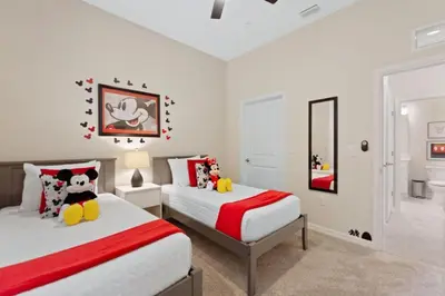 a bedroom with two beds and a mirror at Edgewater Escape At Storey Lake By Shine Villas #904 in Kissimmee