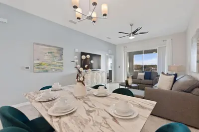a dining room and living room with a table and chairs at Edgewater Escape At Storey Lake By Shine Villas #904 in Kissimmee