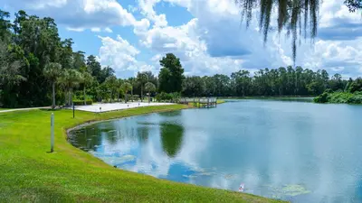 a large lake in a park with green grass at Enchanting Escape 3 Bedroom Minutes from Disney! in Kissimmee