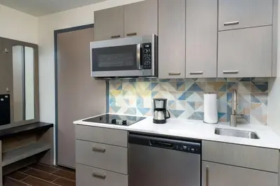 a kitchen with a sink and a microwave at Hyatt House Orlando Airport in Orlando