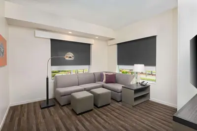 a living room with a couch and a lamp at Hyatt House Orlando Airport in Orlando