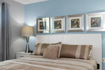 a bedroom with a bed with four pictures on the wall at Amazing Cozy Private Pool - 4404 in Kissimmee