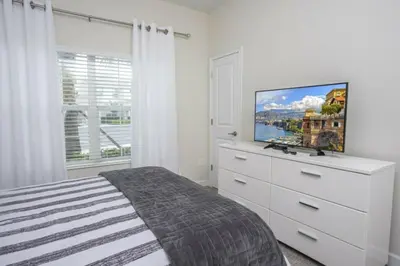 a bedroom with a white dresser with a tv on it at Amazing Lovely Private Pool 4844 in Kissimmee
