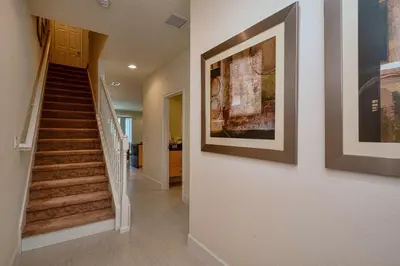 a hallway with stairs and a painting on the wall at 1523 Cozy Astonishing wPrivate Pool in Orlando