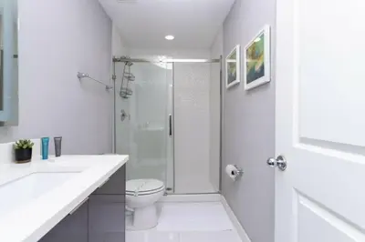 a white bathroom with a shower and a toilet at Modern 4 bedroom Home Private Pool 4451 in Kissimmee