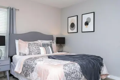 a bedroom with a bed and two pictures on the wall at Modern 4 bedroom Home Private Pool 4451 in Kissimmee