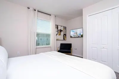 a white bedroom with a bed and a window at 4774 Gorgeous Townhome in Kissimmee