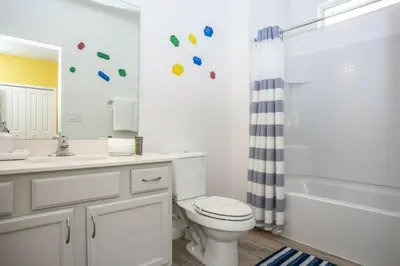 a bathroom with a toilet and a sink and a tub at 2606YA Luxurious En-Suite Single Home Pool in Kissimmee